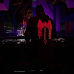 A shot from behind the decks in a dark club with purple lighting. The focus is on the music and the atmosphere we create together on the dance floor.