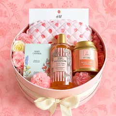An "all things pink" hamper for the woman who loves a bit of pampering. This round pink box includes an H&M eye mask, Oh Cha tea, a Zara mini perfume, and Nykaa shower gel.