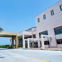 The main facade of Konark Academy, showcasing its modern, block-like forms and large glass windows. The design balances solid mass with transparent elements, creating a dynamic and contemporary architectural statement.