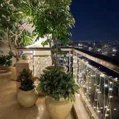 Here’s how I get balconies ready for the festive season. This cozy corner in a Gurgaon high-rise features a mix of tall and bushy plants in custom fibre pots, all lit up with fairy lights for a magical evening vibe.