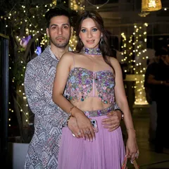 A close-up of the couple, highlighting the intricate print of the man's jacket. It's a great example of a modern festive look for men.