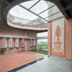 Art is not an afterthought; it is part of the architecture itself. This terracotta mural depicting the Dandi March is integrated into the brick wall of a courtyard, turning a structural element into a powerful storytelling canvas.