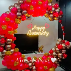 For a modern and stylish celebration, I create these circular balloon backdrops. This one uses a vibrant mix of pink and gold balloons and features a bright 'Happy Anniversary' neon sign, perfect for taking memorable photos.