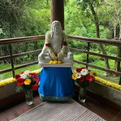 A statue of Paramhansa Yogananda at our retreat, adorned with a fresh flower garland. Set against a backdrop of lush greenery, this sacred spot invites quiet moments of reflection and prayer.