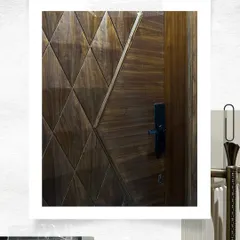 A close-up look at a custom veneer door with a geometric diamond pattern. The high-gloss finish highlights the natural grain of the wood, creating a dynamic and luxurious surface.