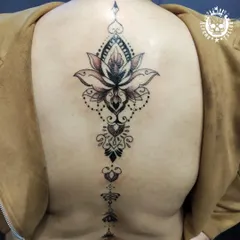 A large and intricate lotus mandala design that flows down the spine. This kind of back piece requires precision and patience, resulting in a stunning and symmetrical work of art.