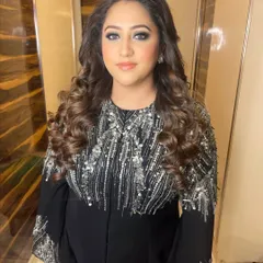 A full view of her stunning cocktail attire. The makeup is bold enough to complement the heavily embellished outfit, creating a look that is pure glamour.