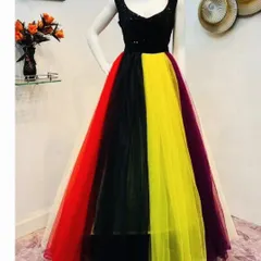 This fun and colorful gown features a black sequin bodice and a multi-colored tulle skirt. It's a great rental choice for a vibrant party or a creative photoshoot.
