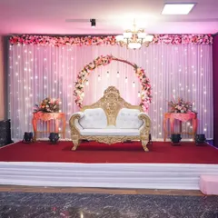 A clean shot of the main wedding stage, featuring a floral arch, elegant couple's sofa, and fairy lights for a magical ambiance.