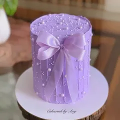 This pretty purple bow cake is a study in texture. Learn to create the vertical buttercream lines, add delicate pearl sprinkles, and tie the perfect satin-finish bow.