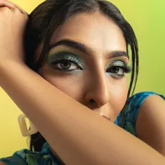 A stunning close-up beauty shot highlighting the model's dramatic green eyeshadow. This image is perfect for showcasing makeup artistry and for beauty-focused campaigns.