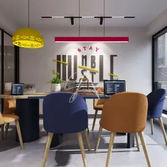 A glimpse into a modern office meeting room where creativity thrives. We used bold color accents, including a vibrant red light fixture and multi-colored chairs, against a backdrop of motivational wall graphics to create an energetic and collaborative workspace.