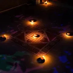 The traditional floor art is fully illuminated by multiple diyas, creating a warm and sacred ambiance. This is the final look, perfect for welcoming light and blessings during Diwali.