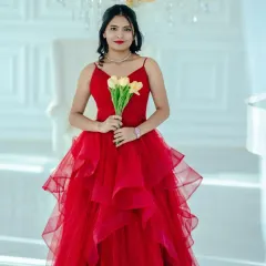 A stunning solo portrait of the bride-to-be, holding a bouquet of yellow tulips that pop against her vibrant red ballgown.