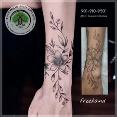 This is how our freehand process works. We sketch the design directly onto your skin, as shown in the smaller image, to create a unique floral piece that perfectly fits your body's contours.