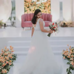 A beautiful shot of the bride on her wedding day. The modern stage decor with the moon prop and floral aisle provides a dreamy and romantic backdrop for her portraits.