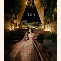 A regal portrait of the bride, seated on a grand staircase, her magnificent lehenga spread around her like a work of art.