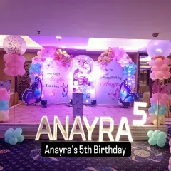Anaya's 5th birthday celebration with a beautiful butterfly theme. The two large arches with custom backdrops and giant butterfly cutouts create a magical entrance to the stage.