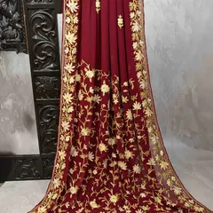 This deep maroon georgette saree features stunning all-over gold floral embroidery. It's a rich and opulent piece that drapes beautifully, perfect for a wedding reception.
