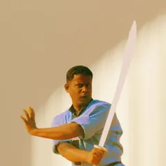 A focused shot of me demonstrating a stance with a traditional Chinese sword (Dao). Sword training teaches precision, focus, and extension of one's energy.