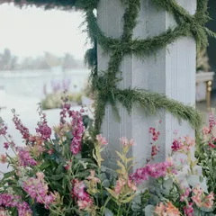 A close-up of the floral and greenery details from Nithya and Payton's wedding. We love layering different textures and colors, like these soft pink snapdragons against the cool stone pillar wrapped in delicate vines.