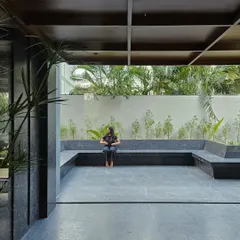 An open-air courtyard with built-in seating made from large slabs of black granite. This tranquil space is designed for employees to relax and recharge, surrounded by curated landscaping.