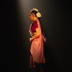 A dramatic, spot-lit moment from a performance, captured in profile. This image highlights the theatricality and storytelling aspect of my dance, a skill that translates directly to creating compelling brand visuals.