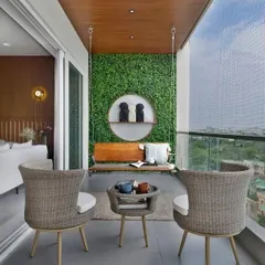 A beautiful example of a modern swing setup. A sleek wooden swing is set against a green wall, creating a stunning focal point. The addition of wicker chairs and a small coffee table makes this a complete and elegant outdoor living room.