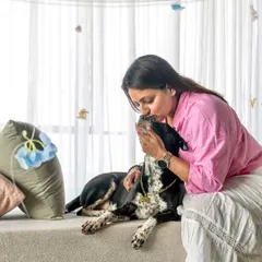 A tender moment between a woman and her dog during a Mother's Day shoot. The soft lighting and gentle kiss on the head create a beautiful, emotional portrait.