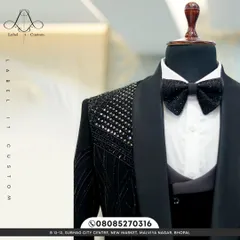 A closer look at the craftsmanship on the black beaded tuxedo. The intricate pattern and sparkling bow tie are a testament to quality and excellence.