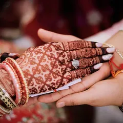 A beautiful shot of the final henna stain during the wedding ceremony, holding hands with the groom. This is the color of love.