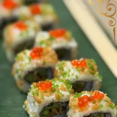My sushi rolls are crafted to be a feast for the eyes and the palate. This roll, topped with tempura crunch and bright tobiko, showcases my commitment to texture, color, and fresh ingredients.