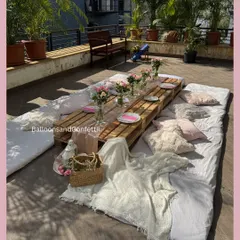 A wider angle of our rooftop boho picnic. You can see the full arrangement of mattresses, cushions, and throws that create a relaxed and inviting atmosphere for guests.