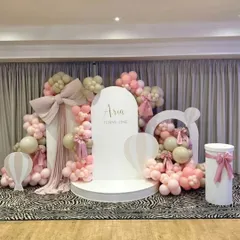 A beautiful Western-style setup for Aria's first birthday, featuring soft pink and beige balloons, elegant bows, and hot air balloon props on a zebra-print floor for a trendy contrast.