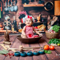 A happy smile from the chef's bowl! I focus on capturing these spontaneous moments of joy. The rustic wooden backdrop and colorful props make for a vibrant and engaging baby portrait.