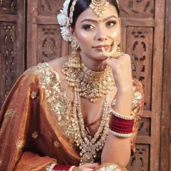 A full view of one of my stunning Polki jewellery sets paired with a rust-colored bridal lehenga. This shows how the complete set, from the matha patti to the long necklace, creates a cohesive and breathtaking look.