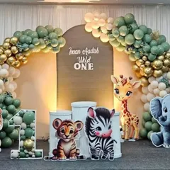 A "Wild One" first birthday party comes to life with a full jungle safari theme. We designed this complete setup featuring a custom backdrop, an organic balloon arch in earthy tones, and adorable animal cut-outs.