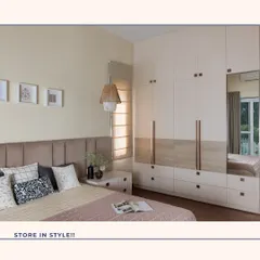This bedroom showcases how to store in style. The floor-to-ceiling wardrobe features a mix of fluted and wood-grain finishes with rose gold handles, while the integrated mirror adds functionality and reflects light beautifully.
