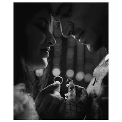 A creative black and white photo focusing on the couple holding their engagement rings, their faces blurred in an intimate moment in the background.
