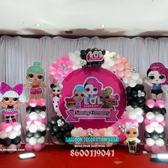 A full view of the vibrant LOL Surprise themed naming ceremony stage. The setup includes multiple character cutouts on balloon pillars and a large, customized central backdrop, perfect for a fun, kid-friendly event.