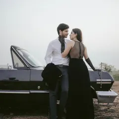 Elegance and intimacy define this moment from a vintage-themed shoot in Goa. Posed against a classic convertible, the couple shares a quiet look, captured in soft light to highlight their connection and the timeless glamour of the setting.