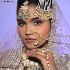A striking pose that showcases the stunning passa (jhoomar) and the flawless airbrushed-finish makeup. The eyes are kept soft to balance the heavy jewelry.