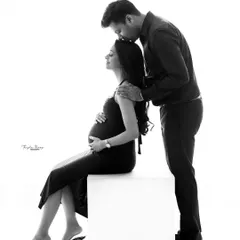 This black and white portrait emphasizes the tender connection between the couple. The simple, clean background keeps the focus entirely on their emotions.