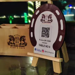 Even the small details are part of the experience. Our cafe tables feature these custom horseshoe-shaped stands with a QR code for easy menu access, blending rustic charm with modern convenience.
