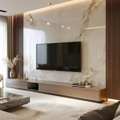 This living room features a statement TV unit with a full-height marble-finish wall and integrated warm lighting. The combination of the luxurious marble, natural wood tones, and sleek low-profile console creates a sophisticated and contemporary entertainment space.