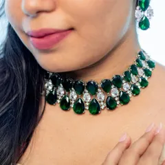 A close-up of a bold and beautiful emerald and zircon choker. This piece is designed to be the star of the show, perfect for pairing with a simple gown or a chic cocktail dress.