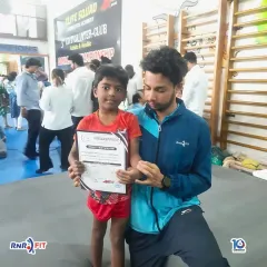 Another one of our young athletes proudly displaying his certificate with his coach. These moments celebrate individual progress and hard work.