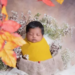 Snug as a bug in a mustard-colored wrap. The pop of yellow is so cheerful, and the tiny ladybug detail adds a touch of good luck.