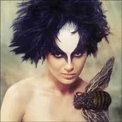 A conceptual beauty portrait of Kangana Ranaut. The dramatic, bird-like makeup and feathered hair transform her into a mythical creature, pushing the boundaries of conventional beauty.