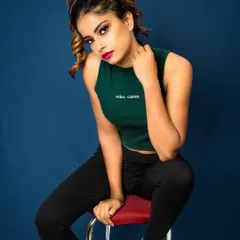 Attitude is everything. This studio shot uses a bold blue background and a confident pose to create a high-energy fashion portrait. The "who cares" on the top speaks volumes, capturing a rebellious and carefree spirit.